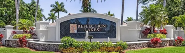 Reflection Lakes entrance monument surrounded by palm trees and tropical landscaping